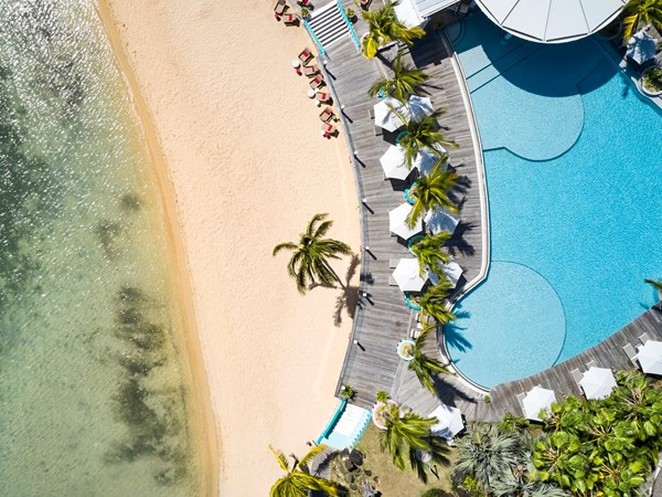 Harmonie parfaite entre piscine et plage de rêve
